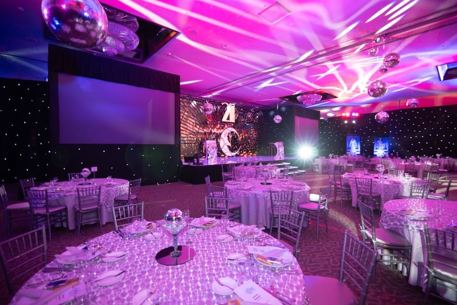 Themed event hall with dinner setup and mood lighting
