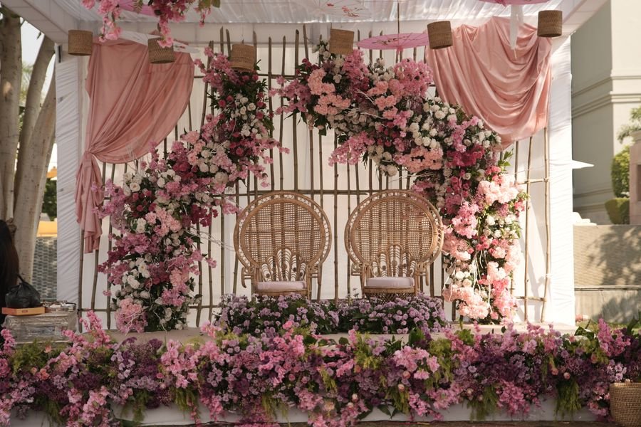 Floral backdrop with cane peacock chairs for a haldi ceremony