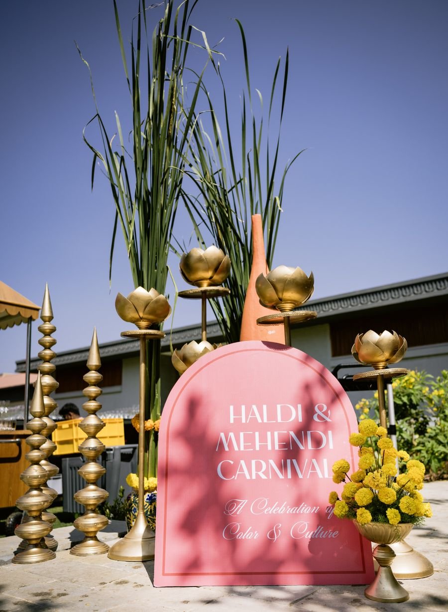Haldi and mehendi welcome signage with brass lotus stands